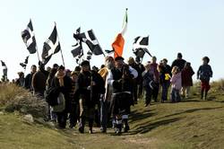 Pipers and a drummer lead the procession into the dunes