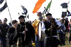 Pipers and a drummer lead the procession into the dunes